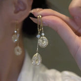 925 silver needle drop earrings with hollow water drop shape, long tassels, and simulated pearl detail