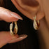 Twisted CZ gold hoop earrings for women with 14K gold plating and sparkling micro pave9 zircon geometric design