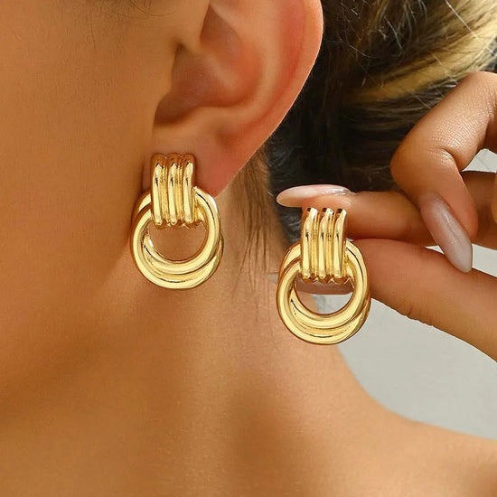Gold twisted round clip-on drop earrings with hollow geometric zinc alloy design for women